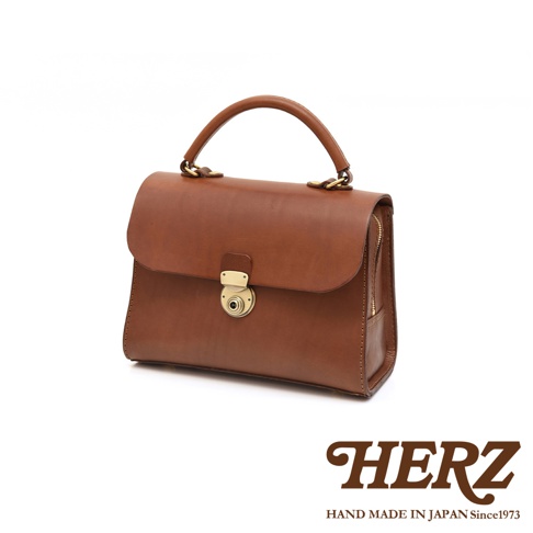 日本HERZ職人手作皮革多功能收納單肩包，採用棕色Latigo牛皮革製作，設有金色鎖扣和拉鍊。