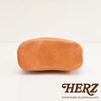 HERZ 品牌標誌及 Handmade in Japan Since 1973 字樣，搭配皮革包的底部視角。