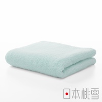 一條淡綠色的今治超長棉毛巾，對折後置於白色背景上，毛巾表面觸感蓬鬆柔軟，右下角有「日本桃雪」的文字標誌。