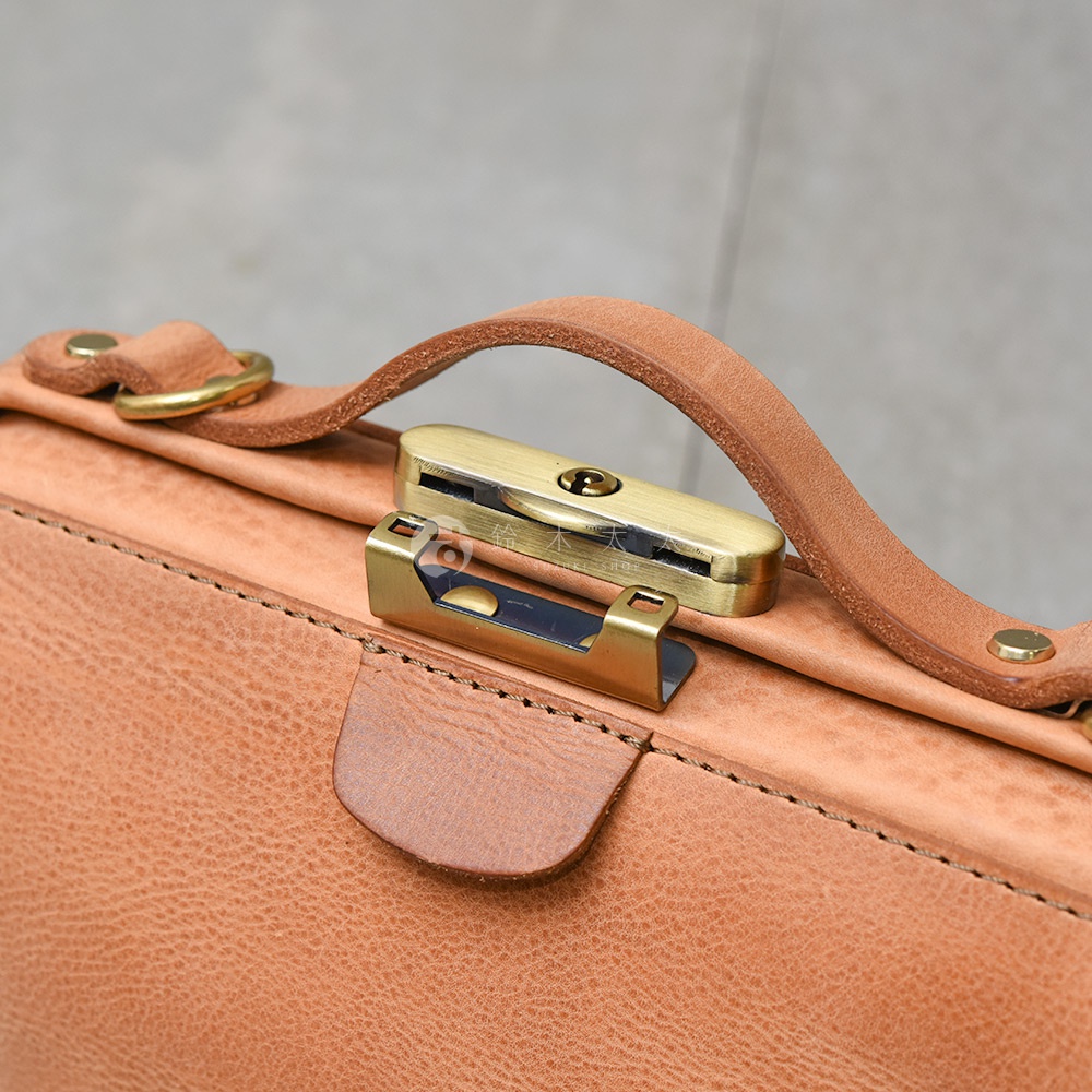 日本HERZ職人手作皮革Organ鎖孔式大開口肩背包 M-7，特寫箱包的黃銅色鎖扣和皮革提把細節