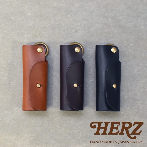 職人手作皮革Organ鑰匙套GS-23，有棕色、深棕色、黑色三種顏色，皆為皮革材質，附有黃銅色金屬扣環與按鈕，設計簡約實用。