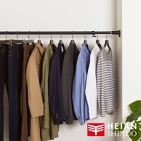 黑色伸縮桿掛著多件男士服飾，包含深藍色牛仔褲、卡其色風衣、軍綠色襯衫、海軍藍西裝外套、灰色西裝外套、淺藍色襯衫、白色襯衫和條紋長袖上衣。