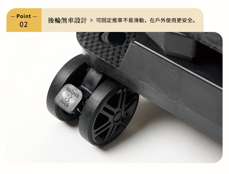圖片顯示購物車後輪裝置的特寫，黑色塑膠材質的輪軸上配有一個標示解鎖與鎖定方向的槓桿開關，藉此可將推車固定在地面以提升戶外使用的安全性。