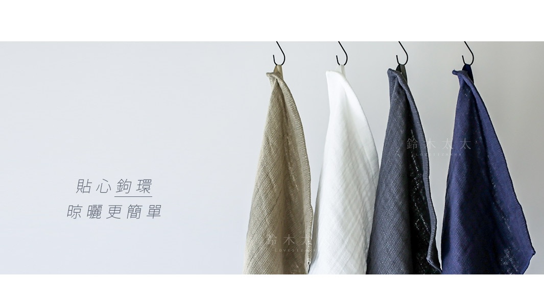 四條2.5層紗浴巾，顏色分別為淺褐色、白色、深灰色和海軍藍，皆以S型掛鉤懸掛。