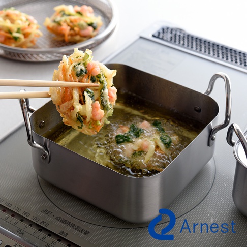 逸品物創不鏽鋼方型炸物鍋組，鍋身為銀色不鏽鋼材質，帶有兩個側把手。鍋內裝有熱油，油中有炸物正在烹調，一雙木筷夾著剛炸好的炸物。背景有濾油網，網上有另外兩個炸物。