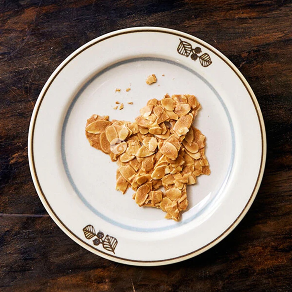 Anyware 美濃燒葉紋復古甜點盤，白色陶瓷盤，盤緣有藍色細線及葉紋圖案，盤中央放著一塊形狀不規則的杏仁脆餅。