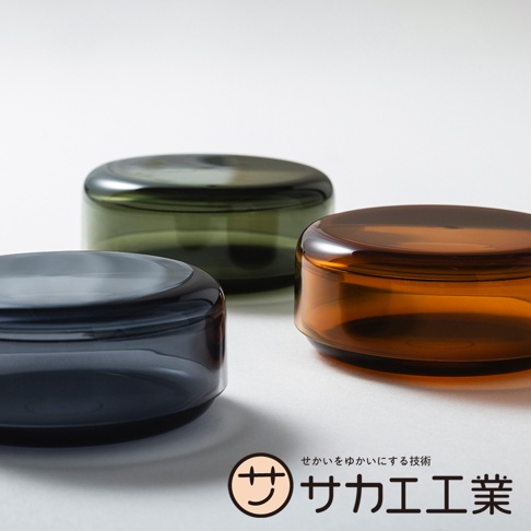 SAKAE 品牌日系風格的圓形半透明收納盒，分別呈現深灰、墨綠和琥珀色，以簡潔的設計和高品質的材質展現。