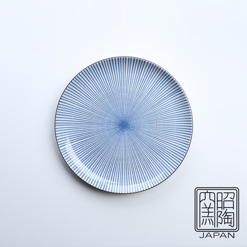 藍色千段十草紋路的白色陶瓷圓盤，中央有同心圓紋飾，邊緣有細膩的藍色線條。