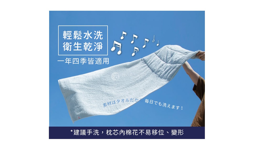 將一條淺藍色毛巾以捲曲方式舉向藍天，毛巾中間有日文和英文標示，上方有音樂符號，下方文字為「建議手洗，枕芯內棉花不易移位、變形」。