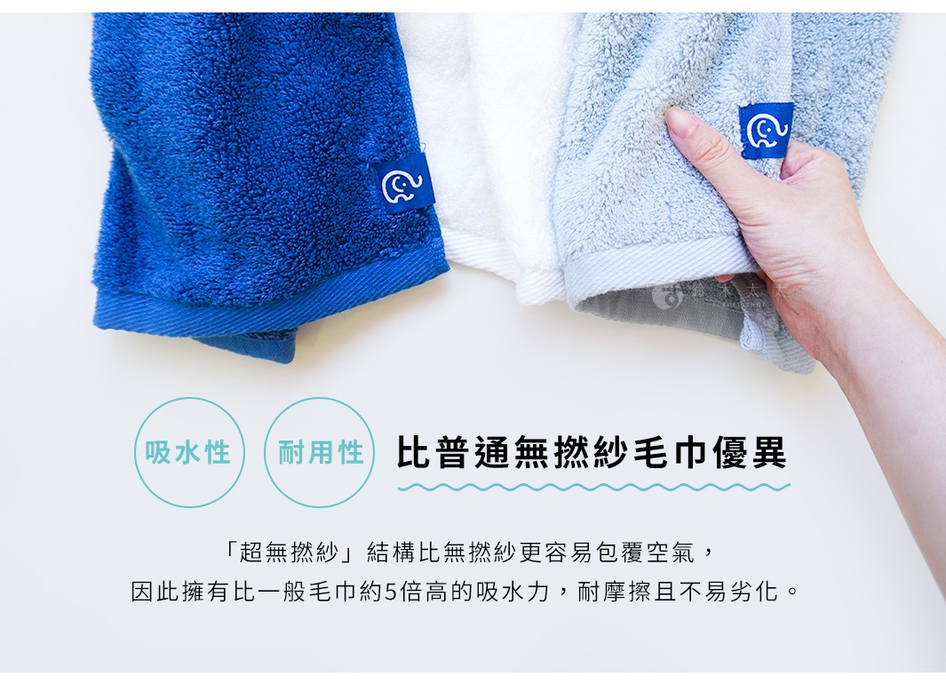 三條不同顏色的毛巾，分別為藍色、白色、淺藍色，其中藍色和淺藍色毛巾上印有可愛的白色大象圖案標籤，淺藍色毛巾由一隻手拿著，圖片下方有標示「吸水性」、「耐用性」，以及「比普通無撚紗毛巾優異」等字樣。