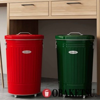 OBAKETSU 品牌手工製附輪垃圾桶，一個為紅色，一個為綠色，放置在木製桌子下方