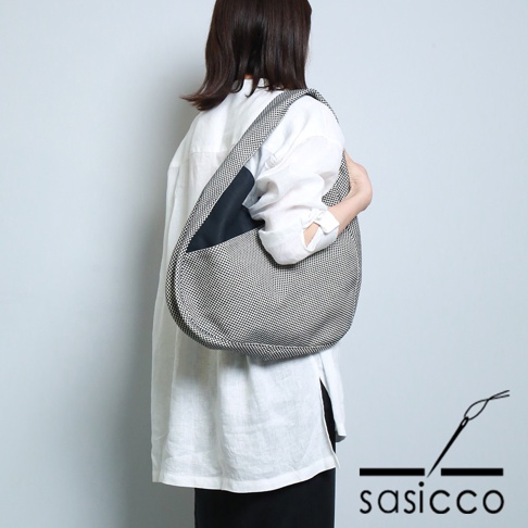 三河木綿刺子織半月包，黑白格紋為主體，搭配黑色拼接，斜挎於身。