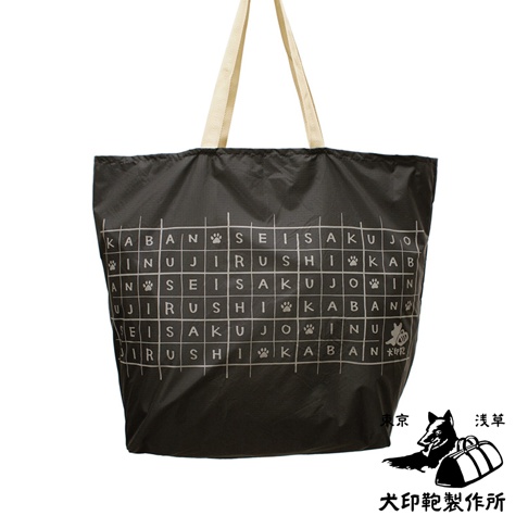 深灰色環保折疊收納購物袋，印有白色網格圖案，內含日文字及狗爪圖案。袋子採用尼龍材質，配有米色織帶提把。右下角有品牌標誌，包含狗的插畫與兩個行李袋，以及日文「犬印鞄製作所」、「東京」、「淺草」字樣。
