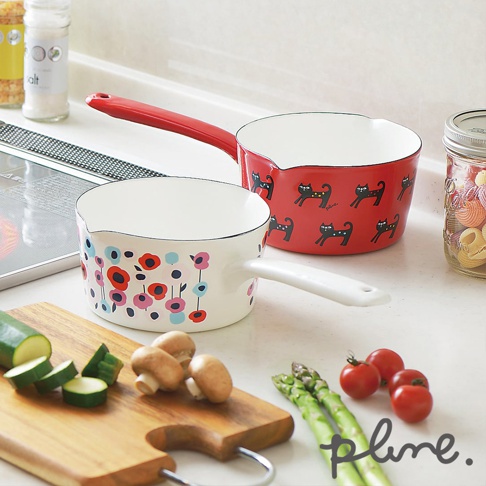 兩個琺瑯單柄牛奶鍋，一個為紅色，印有黑色小貓圖案，另一個為白色，印有多彩花朵圖案。