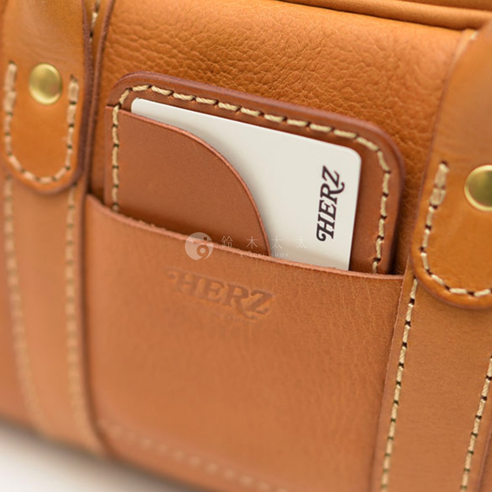 HERZ 職人手作皮革包上的卡夾，露出印有 HERZ 商標的白色卡片