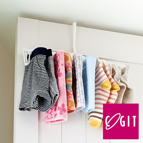 白色旋轉式晾衣架，掛有條紋內褲、灰色內褲、粉色毛巾、橘色毛巾、灰色毛巾、藍色毛巾、條紋襪子和米色襪子。