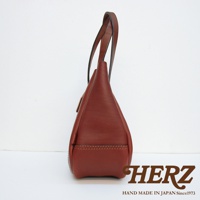 職人手作皮革仕女托特包 T-10，側邊視角，呈現酒紅棕色。包身由光滑皮革製成，線條簡潔，提把為細長型，帶有品牌標誌。