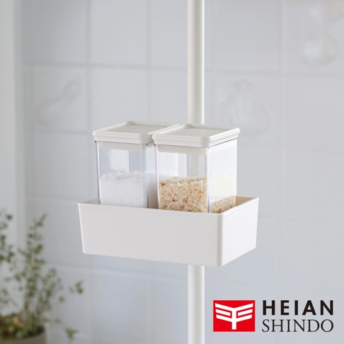 白色長方形置物架上，兩個透明方形儲物盒內分別裝有白色顆粒物和淺棕色細碎物，置物盒與盒蓋均為白色，架子固定在白色圓形直桿上。