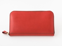 鮮紅色皮革長夾，具備金色拉鍊與同色系皮革拉頭，周圍以深棕色縫線勾勒邊緣，展現職人手作質感。