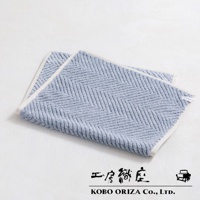 淺藍色棉麻混紡浴墊，織有經典人字紋，邊緣為白色滾邊。