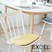 THE OWL 進階款隨身坐墊，黃色絨面材質，放置於白色木質餐椅上，坐墊邊緣為黑色。