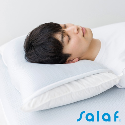 淺藍色枕套疊在白色枕頭上，一名男子側臥，頭枕在枕頭上。枕套表面有細小的網格紋理。