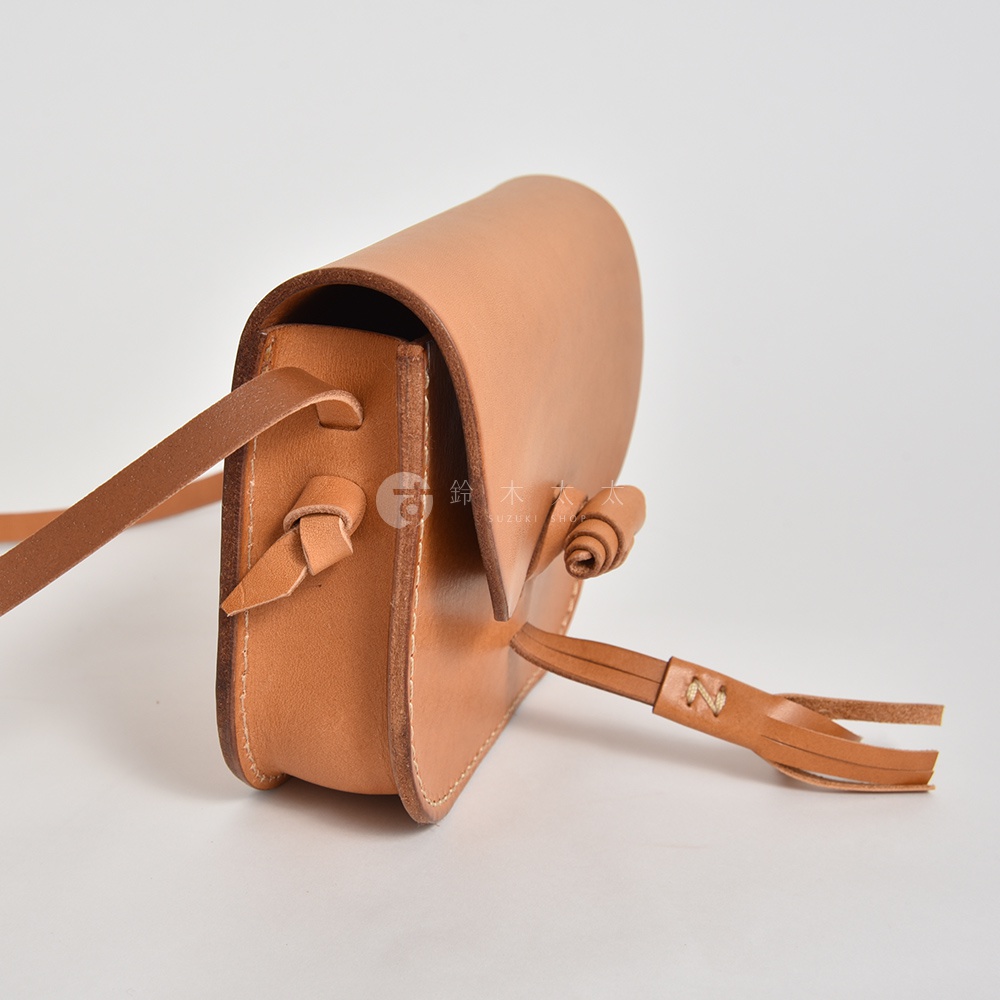 職人手作皮革流蘇側背包，淺棕色原色皮革，帶有流蘇裝飾與皮革繫繩。