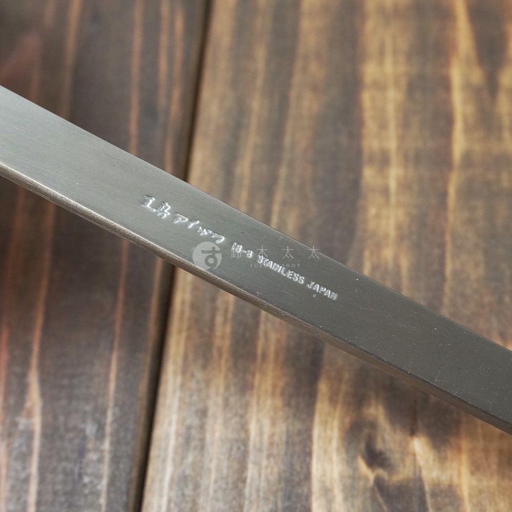 不鏽鋼萬用瀝水湯勺的長柄特寫，表面有蝕刻的日文及「18-8 STAINLESS JAPAN」字樣。