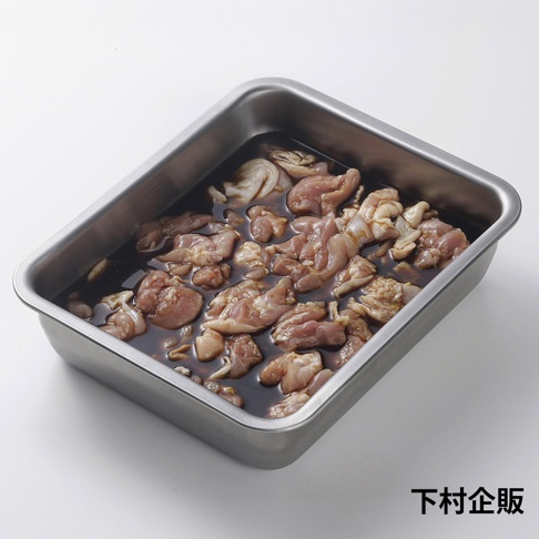 下村企販標誌旁，一個不鏽鋼長方形調理盤裝滿了浸泡在深褐色醬汁中的雞肉塊。