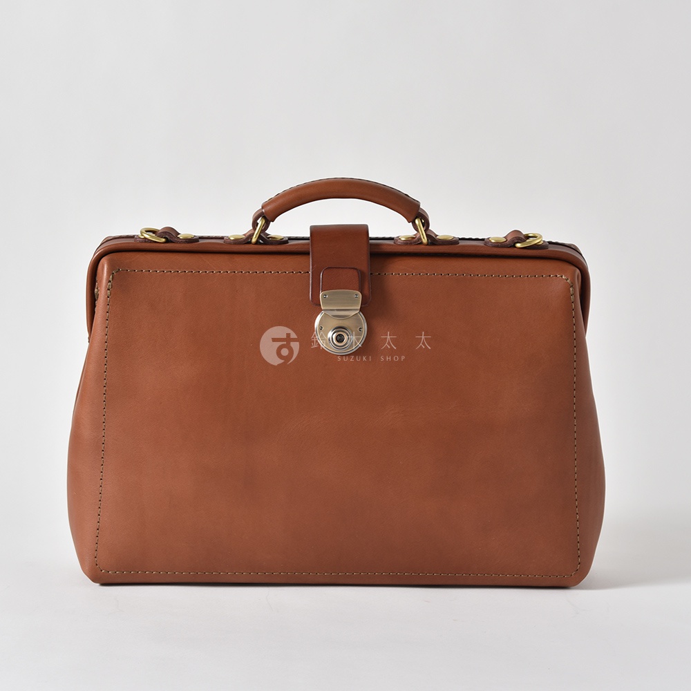 棕色皮革製成的職人手作軟式杜勒斯三用背包，配有銀色金屬鎖扣、皮革提把和縫線細節。