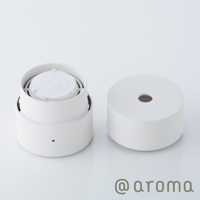 白色圓柱形隨身精油香氛機，機身分為上下兩部分，上方可見白色濾芯，下方機身有一黑色小孔。右側為機身頂蓋，頂部中央有一圓孔。