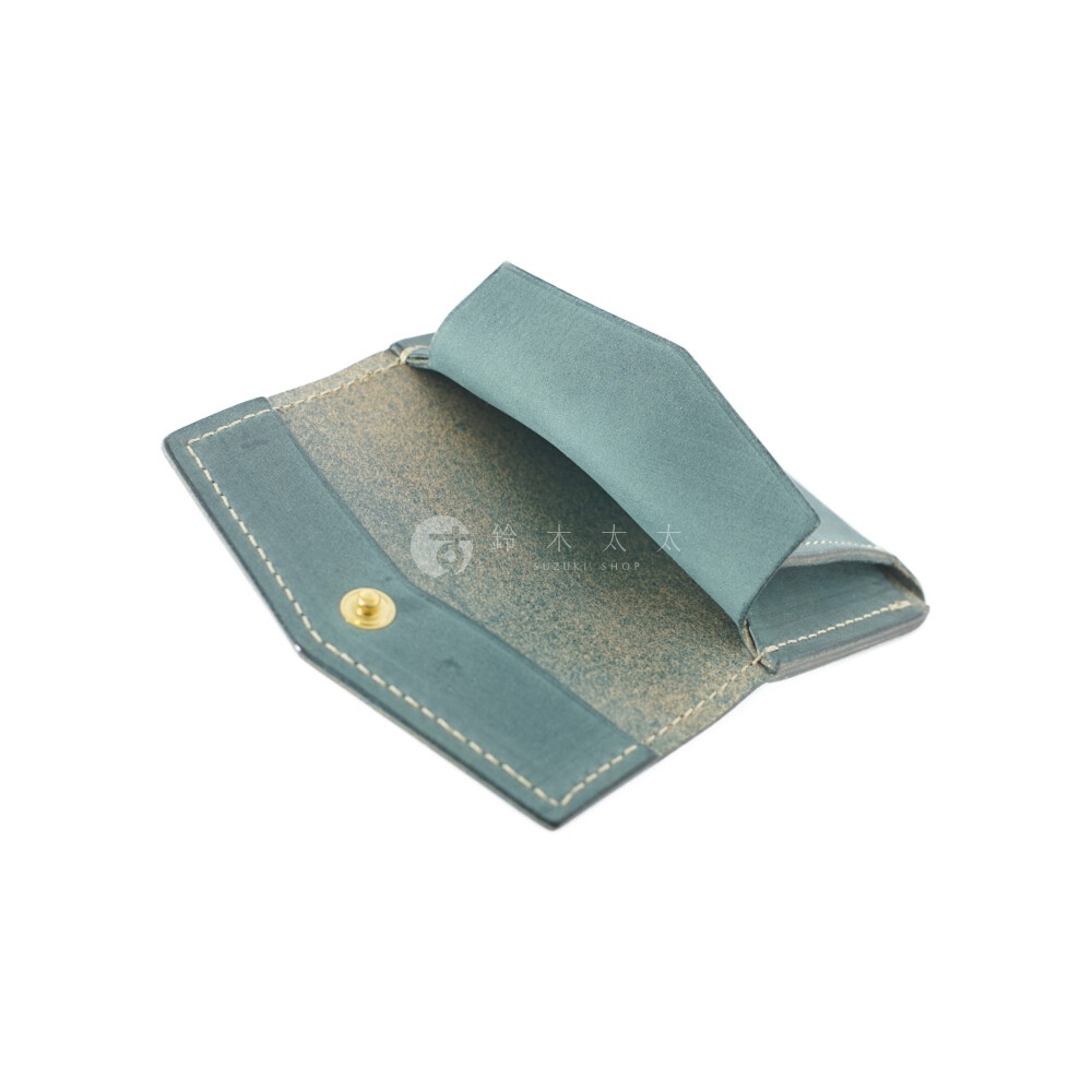 北海道KASANE 職人手作義大利Texas皮革迷你雙折短夾，藍綠色皮革翻開展示內裡，中央有金色釦子，並有品牌日文及英文 Logo 標示。