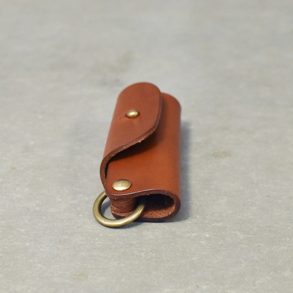 職人手作皮革鑰匙套，採用棕色皮革製成，帶有金屬按扣和鑰匙圈，設計簡約實用。