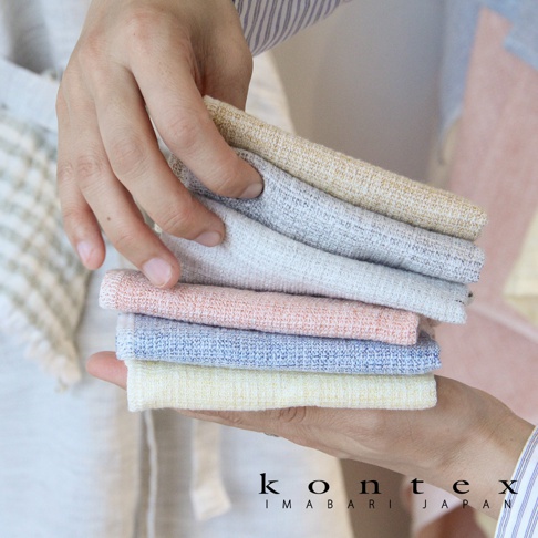 一疊 MOKU LINEN 輕薄速乾棉麻拭巾，顏色包含淺黃、淺藍、粉橘、淺灰、米白和淺金，質地輕柔，表面呈現細緻織紋。