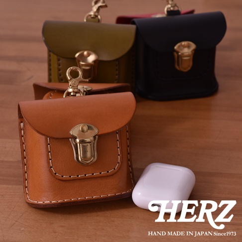 職人手作皮革耳機收納包，展示有棕褐色、橄欖綠、黑色和紅色等多種顏色，均配有金色金屬鎖扣和鑰匙圈。