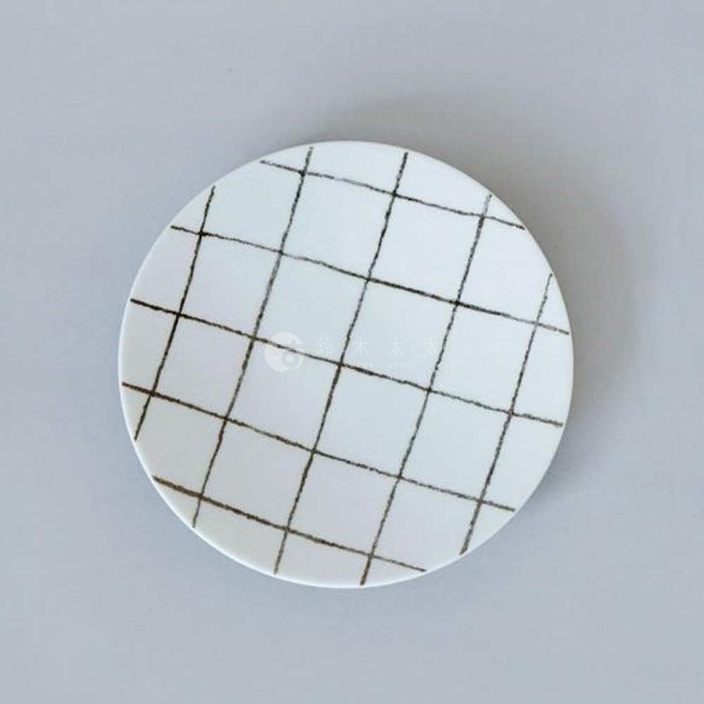 白色圓形美濃燒點心盤，表面以手繪黑色線條構成斜向網格紋路。