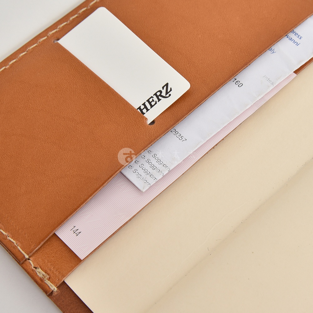 咖啡色皮革製成的筆記本內頁，右側有標籤，上面印有HERZ字樣