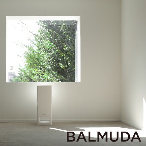 The Pure 空氣清淨機，白色直立式設計，正面有進氣口和品牌標誌，置於室內角落，背景為窗戶外的綠葉，營造簡潔明亮的空間感。