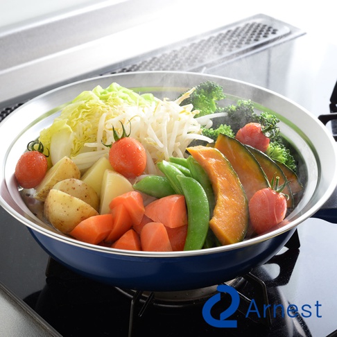 不鏽鋼蒸盤內盛滿多樣蔬菜，包含花椰菜、南瓜、荷蘭豆、紅蘿蔔、馬鈴薯、豆芽菜、大白菜及小番茄，盤緣為銀色不鏽鋼，蒸煮中冒出蒸氣。