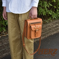 職人手作皮革立體口袋兩用單肩包，採用棕色皮革製成，設有拉鍊主隔層、前方翻蓋口袋及金屬扣環，可單肩或手提。