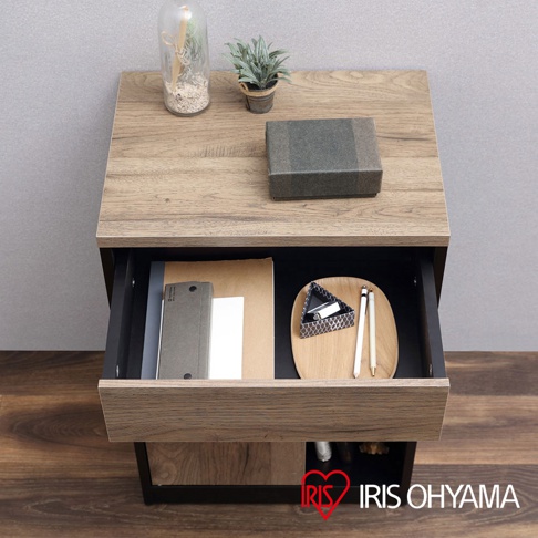 木質抽屜收納櫃，木紋桌面，黑色櫃身，抽屜內有文件、筆和收納盤，櫃下有滾輪，展示於木地板和灰色背景前。