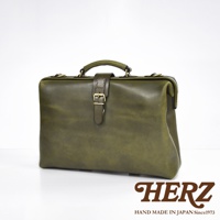 職人手作皮革軟式杜勒斯包，深綠色，附有金屬扣帶和提把，展現皮革自然紋理。