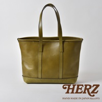 橄欖綠皮革經典托特包，簡約方形設計，雙提把，底部以較深色皮革加固，縫線清晰，質感細膩。