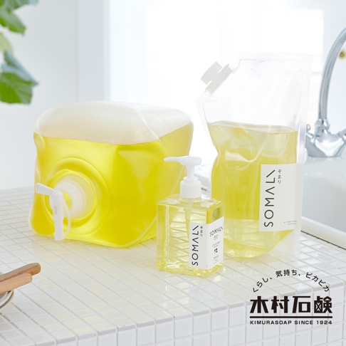 SOMALI 按壓式天然洗碗精，包含一個透明方形按壓瓶裝洗碗精，以及一個裝有黃色洗碗精的補充包，旁邊還有一個大型填充式黃色洗碗精容器，帶有白色水龍頭。