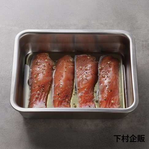 下村企販的不鏽鋼調理保存盒中，擺放著四塊撒有黑白胡椒粒的生鮭魚。