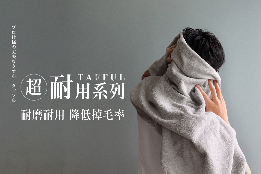 TAFFUL 超耐用系列灰色浴巾，材質柔軟，一位男子正用浴巾擦拭頭髮。