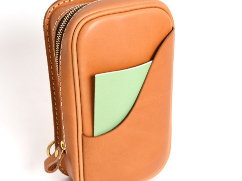 職人手作皮革兩用直立型斜背包 (F-103)， tan 色牛皮材質，側邊有拉鍊開合，正面有一個淺綠色卡片插槽。