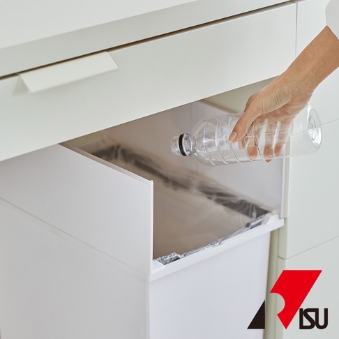 一只手將空塑膠瓶放入白色對開分類垃圾桶內，垃圾桶藏於廚櫃下方。