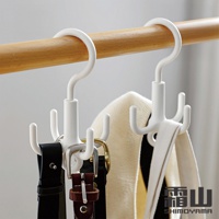 兩個白色ABS材質的四爪掛勾，掛在木質衣桿上，分別掛著皮帶和圍巾。