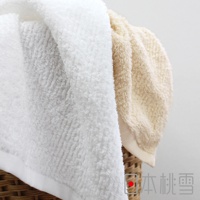 今治細絨毛巾，材質為柔軟絨毛，呈現純白色與淺米色兩款，毛巾表面細緻蓬鬆，質感清晰可見，部分疊放於竹編籃中。